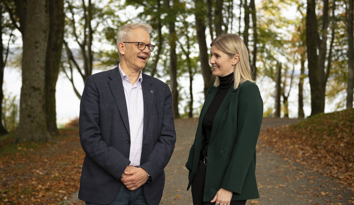 
mann og kvinne snakker sammen omringet av trær