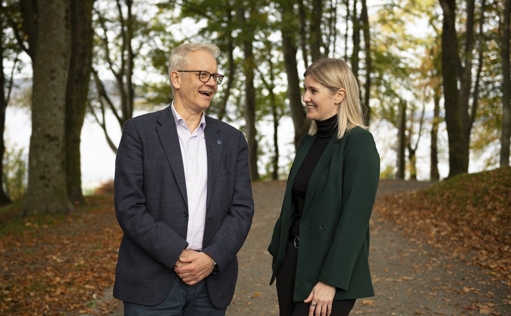 mann og kvinne snakker sammen omringet av trær