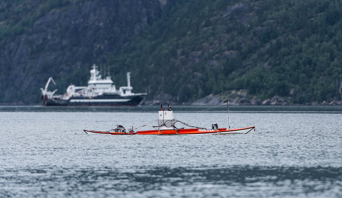 
En kajakkdrone på fjorden med et forskningsfartøy i bakgrunnen