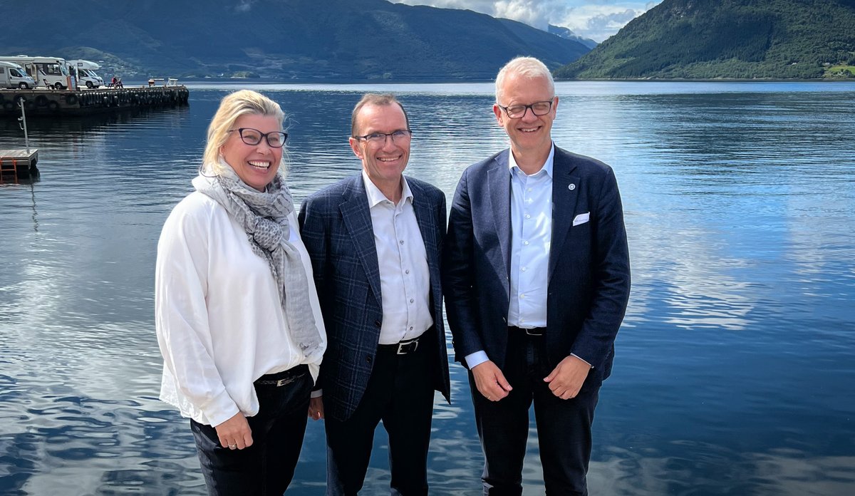 foto av tre personer foran fjorden i Rosendal