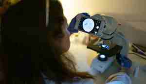 foto av kvinne som ser i mikroskop