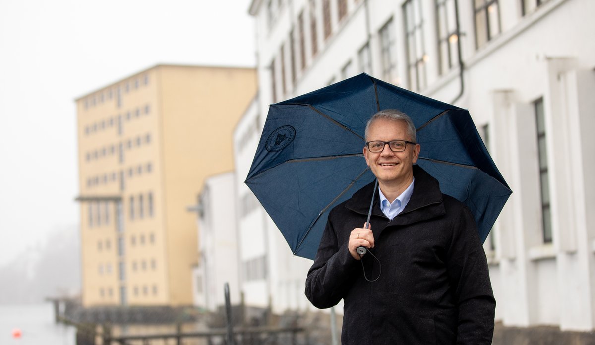 
Nils Gunnar står under paraply og smiler.