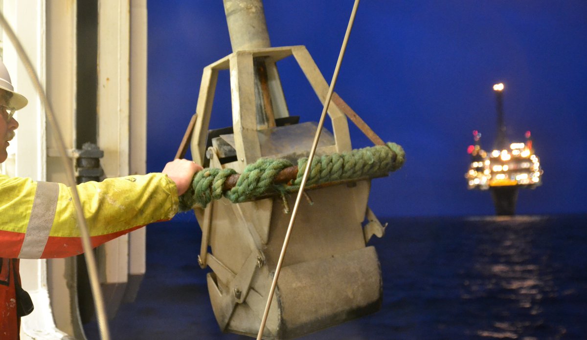 Prøvetakningsutstyr på vei fra båt og ned i havet, like ved en oljeplattform