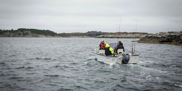 

foto av tre stangfiskere i en båt