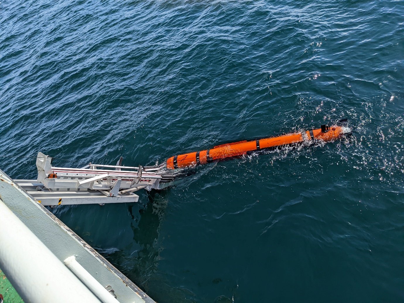 Photo of the AUV in the water leaving the stinger