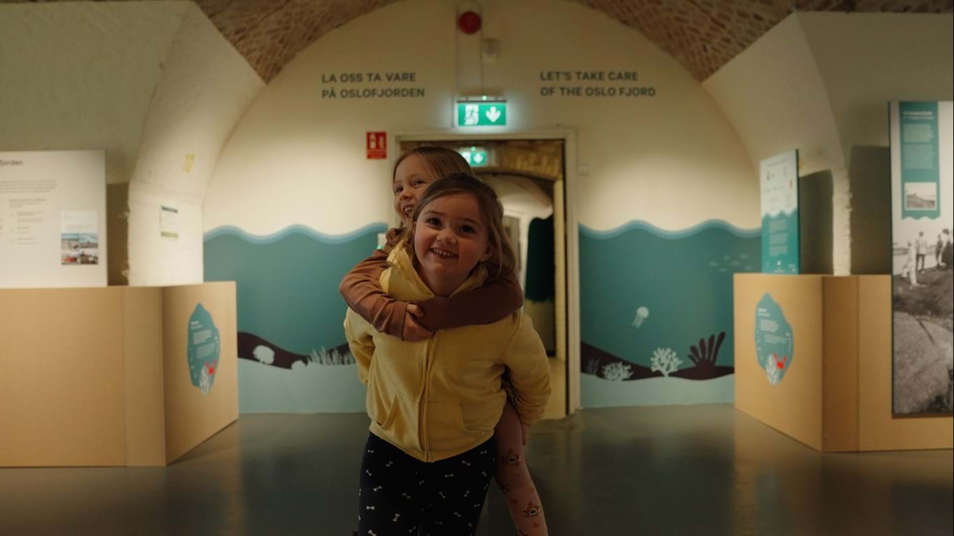 Figuren viser to glade barn inne på Besøkssenter Oslofjorden