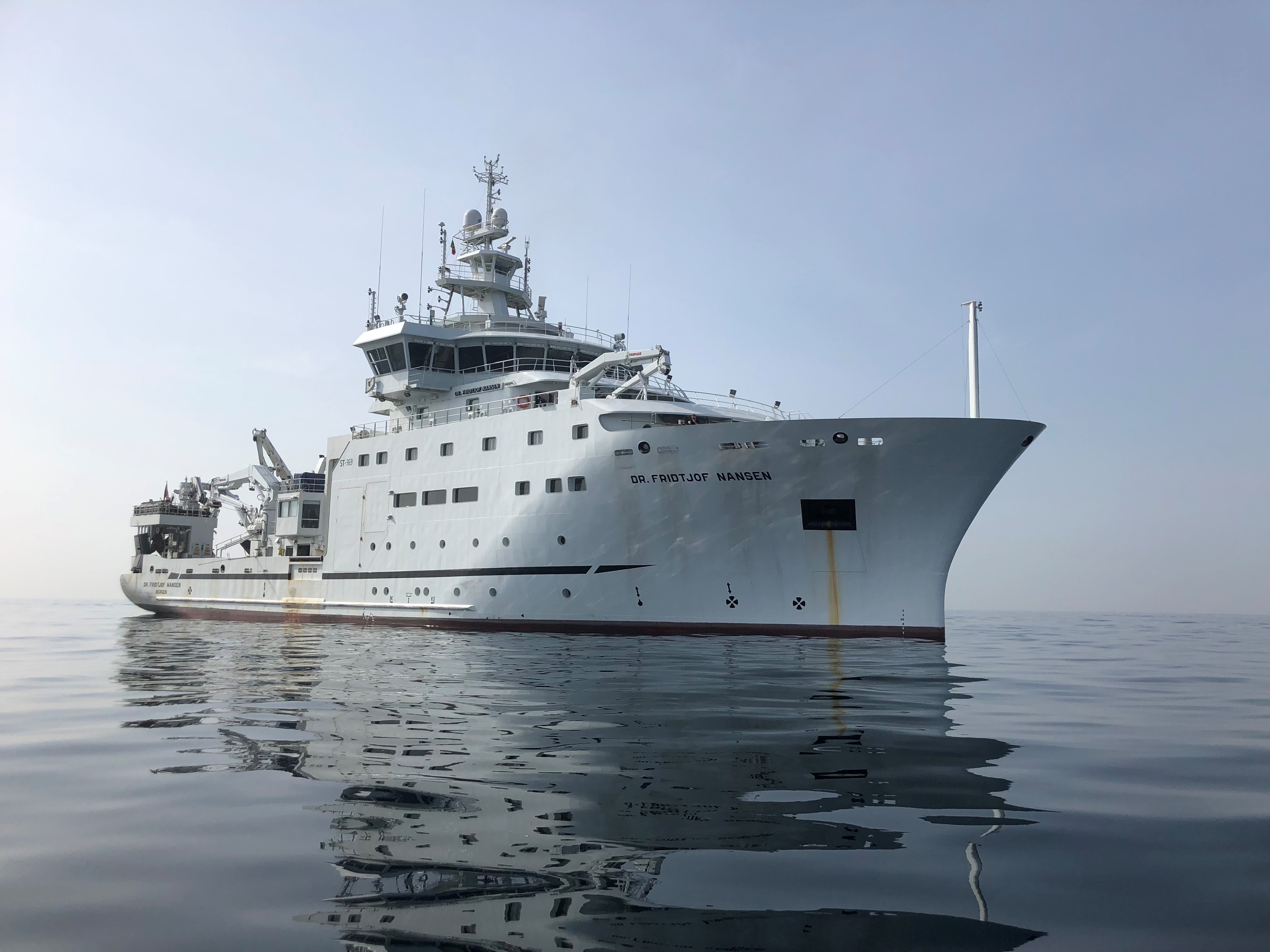 Et stort hvitt forskningsskip, «Dr. Fridtjof Nansen», på stille sjø.