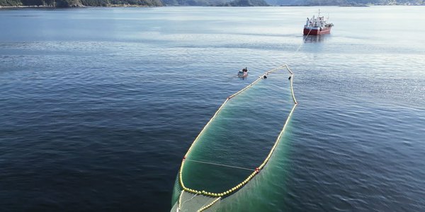 

Drone photo of a fishing vessel towing a special fish net cage.